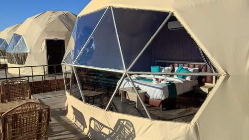 a tent with a bed and chairs in it at camp scylla Wadi Rum in Wadi Rum