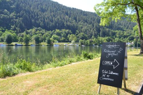 a sign in the grass next to a lake at Uferdeck - Boutique Hotel in Traben-Trarbach