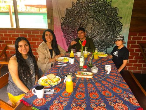 Un groupe de personnes assises autour d'une table avec de la nourriture dans l'établissement Aroldo Amazon Lodge, à Puerto Maldonado
