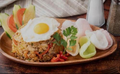 un plato de comida con huevos y verduras en una mesa en Batur cottage en Kubupenlokan