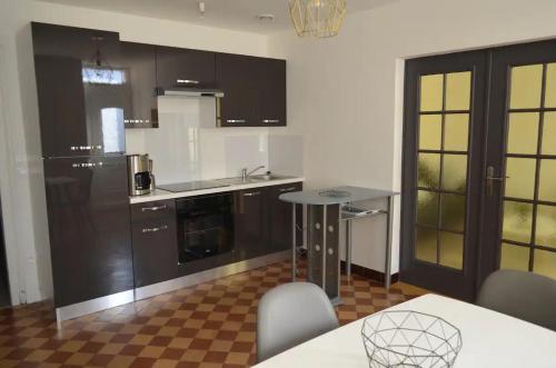 a kitchen with brown cabinets and a table and a counter at Agréable maison petit jardin à 7 minutes de Reims in Pargny-lès-Reims