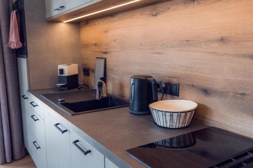 a kitchen with a sink and a coffee maker on a counter at Apart Eder in Schwendau