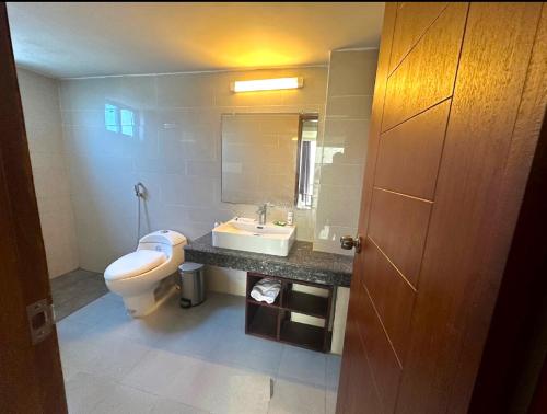een badkamer met een toilet, een wastafel en een spiegel bij Annex Suites Bogra - CityCentre in Bogra