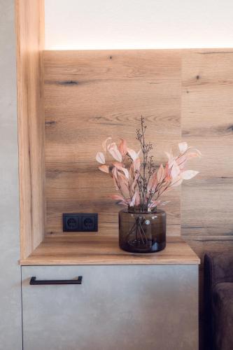 a vase of flowers sitting on top of a cabinet at Apart Eder in Schwendau