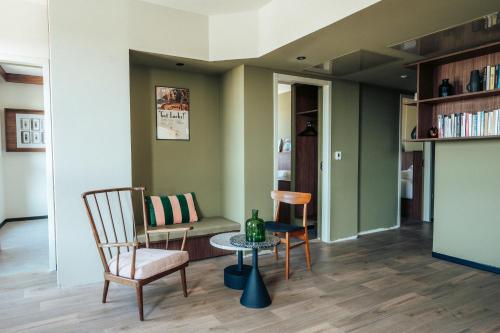 a living room with a chair and a table at JOST Hotel Montpellier Centre St Roch in Montpellier