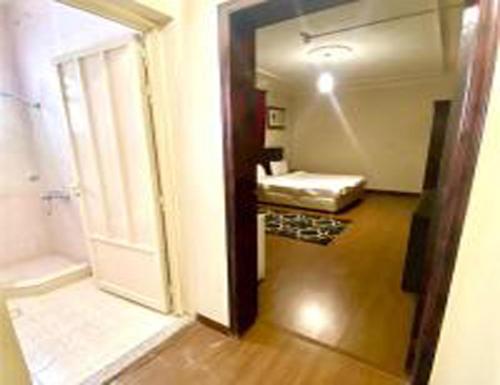 um corredor com um quarto com uma cama e uma porta em العنوان للوحدات المخدومة ALanwaan of the units served em Dammam