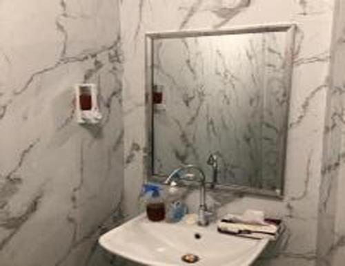 a bathroom with a sink and a mirror at العنوان للشقق المخدومة ALanwaan of the units served in Dammam