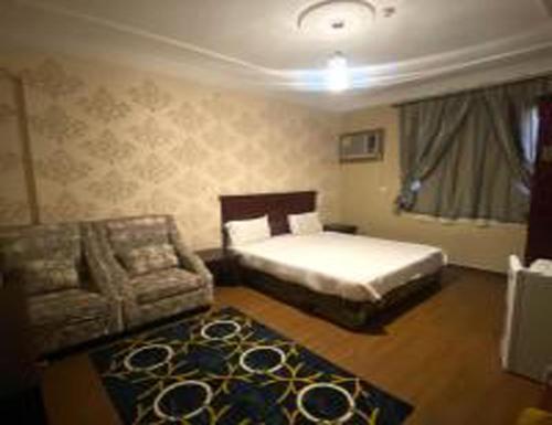 a bedroom with a bed and a chair and a couch at العنوان للشقق المخدومة ALanwaan of the units served in Dammam