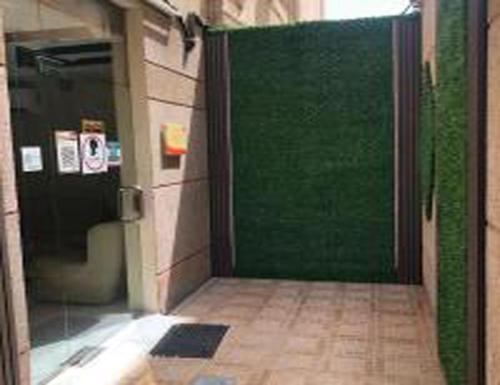 a green door in a building with a tile floor at العنوان للشقق المخدومة ALanwaan of the units served in Dammam