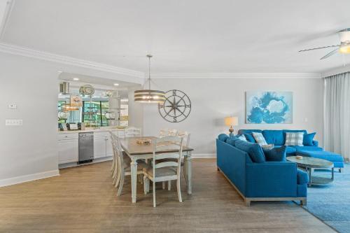 a living room with a blue couch and a table at Phoenix on the Bay 1228 in Orange Beach