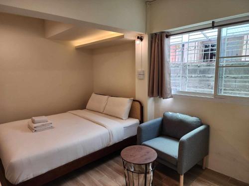 バンコクにあるCanal View Lo-ha guest house, Contactless Check-inのベッドと椅子付きの小さな部屋です。