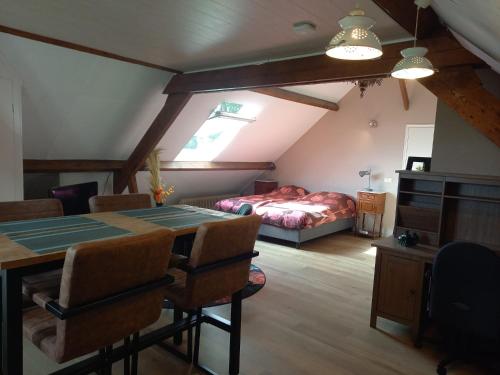 mooie familie groepsaccomodatie aan de bosrand في Overloon: غرفة نوم مع طاولة وسرير في غرفة