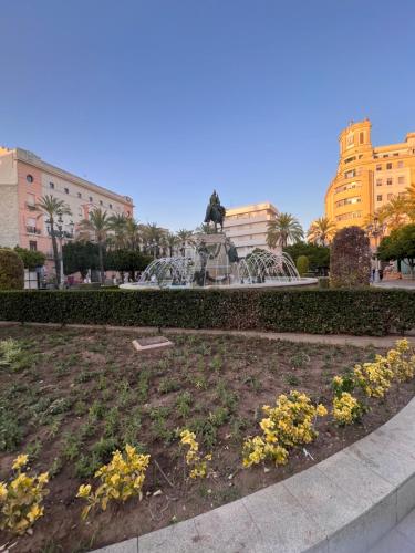 una estatua de un león en un parque con flores en Apartamentos La Albariza Jerez Centro, en Jerez de la Frontera