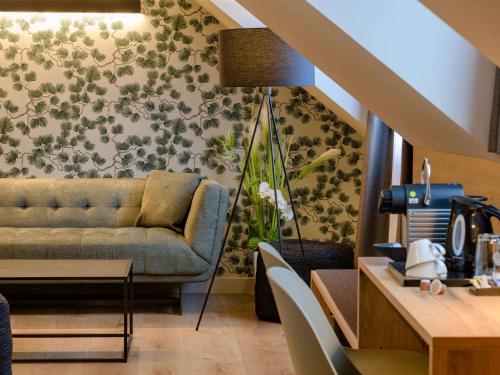 uma sala de estar com um sofá e uma mesa em Mercure Hotel München Altstadt em Munique