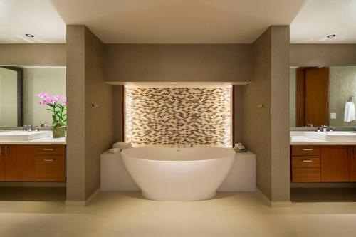 a bathroom with a large tub and two sinks at Hyatt Regency Maui Resort & Spa in Lahaina