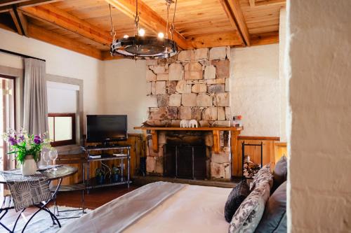 a living room with a fireplace and a couch at Anglers Court in Dullstroom