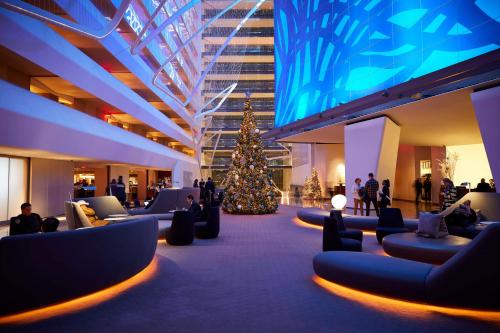 a christmas tree in the middle of a lobby with people at Conrad New York Downtown in New York