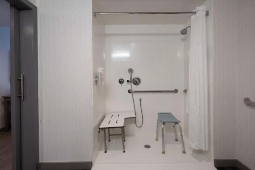 a white bathroom with a bench and a stool at Hampton Inn & Suites Miami Wynwood Design District, FL in Miami