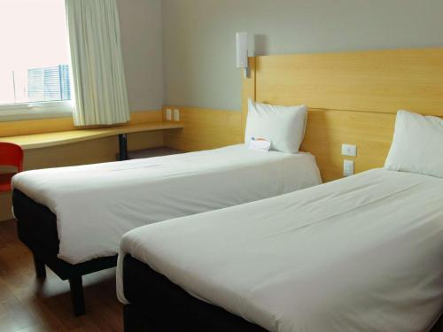 a hotel room with two beds and a window at ibis Puerto Montt in Puerto Montt