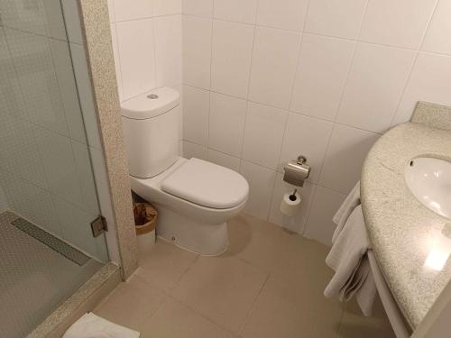 Baño blanco con aseo y lavamanos en ibis Puerto Montt, en Puerto Montt