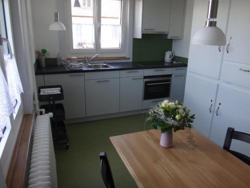 a kitchen with a table with a vase of flowers on it at BnB Hopfengrün Langenthal in Langenthal