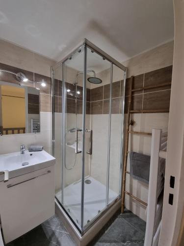 een badkamer met een glazen douche en een wastafel bij Petit mazet in Sainte-Maxime