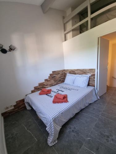 een slaapkamer met een bed met twee rode handdoeken erop bij Petit mazet in Sainte-Maxime