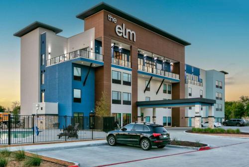 a green car parked in front of a building at The Elm, a Ramada by Wyndham in Little Elm