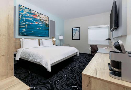 a hotel room with a bed and a flat screen tv at The Elm, a Ramada by Wyndham in Little Elm