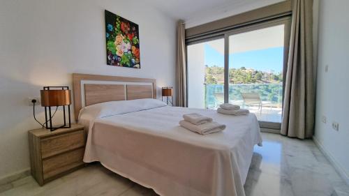a bedroom with a bed with two towels on it at Torre Lugano - Gran terraza con vistas in Benidorm