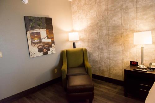 a room with a chair and a desk with two lamps at Distill-Inn in Bardstown