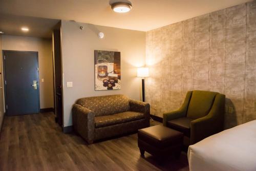 a hotel room with a bed and a chair at Distill-Inn in Bardstown