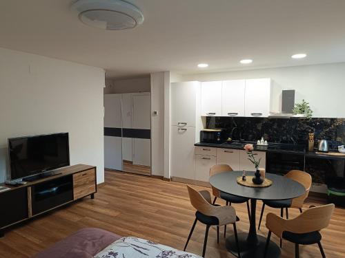 a living room with a table and chairs and a kitchen at Studio apartman Peti in Varaždin