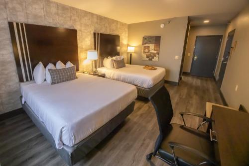 a hotel room with two beds and a desk at Distill-Inn in Bardstown