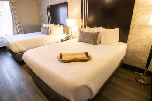 a hotel room with two beds with a tray on them at Distill-Inn in Bardstown