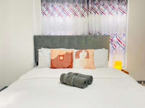 - une chambre avec un lit blanc et une tête de lit gris dans l'établissement Condo in EDSA Netflix and SmartTV FreeAccess to POOL and GYM, à Manille