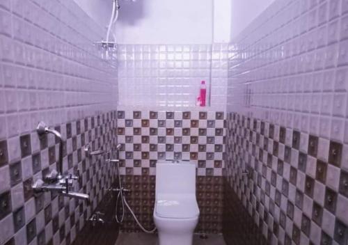 baño con aseo y paredes de azulejos en Bomzan Homestay by StayApart, en Takdāh
