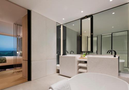 a bathroom with two sinks and two mirrors at Taj The Trees, Mumbai in Mumbai