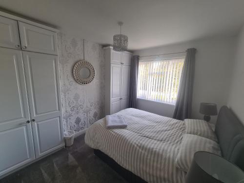 a small bedroom with a bed and a window at L & J Escapes - 8 Bedrooms suitable for Contractors and Families- Private parking available for 6 vehicles in Coseley