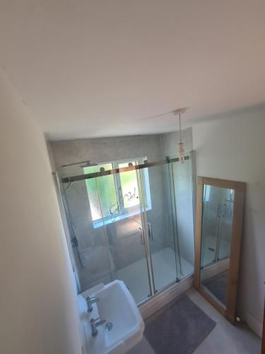 a bathroom with a glass shower and a sink at L & J Escapes - 8 Bedrooms suitable for Contractors and Families- Private parking available for 6 vehicles in Coseley