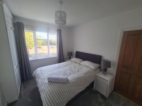 a small bedroom with a bed and a window at L & J Escapes - 8 Bedrooms suitable for Contractors and Families- Private parking available for 6 vehicles in Coseley
