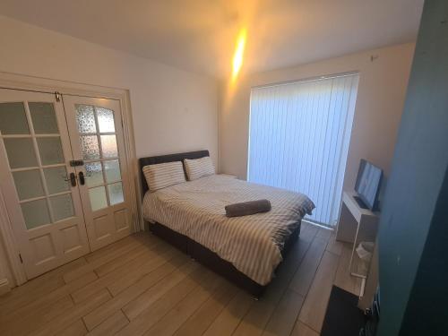 Dormitorio pequeño con cama y TV en L & J Escapes - 8 Bedrooms suitable for Contractors and Families- Private parking available for 6 vehicles en Coseley