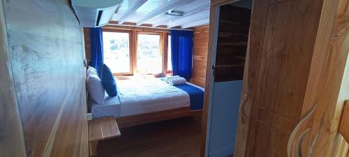 a small bedroom with a bed and a window at familykomodocruise in Labuan Bajo