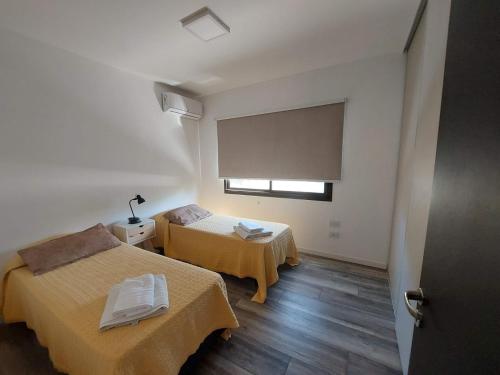 ein kleines Zimmer mit zwei Betten und einem Fenster in der Unterkunft Duplex de Categoria - con estacionamiento gratuito in Cordoba