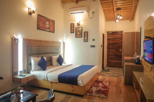 ein Schlafzimmer mit einem Bett und einem TV in einem Zimmer in der Unterkunft The Lake Ambience Resort in Bhīm Tāl