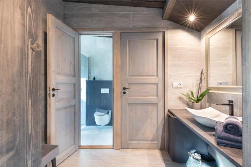 a bathroom with a wooden door and a sink at Dream Corner Nordic in Laulasmaa