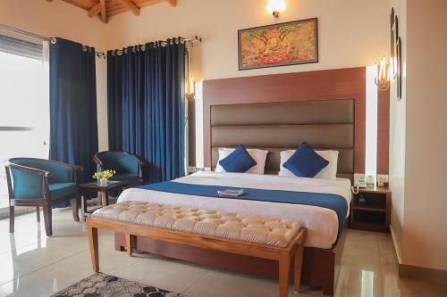 a bedroom with a large bed with blue pillows at The Lake Ambience Resort in Bhīm Tāl