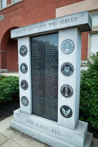 a monument in front of a brick building at Distill-Inn in Bardstown