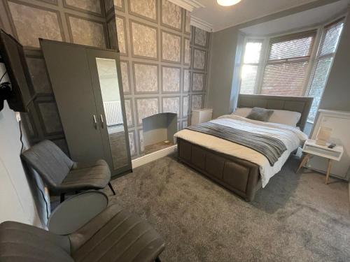 ein Schlafzimmer mit einem Bett und einem Stuhl in der Unterkunft Lovely 4 bedroom Victorian house with back courtyard in Stoke on Trent