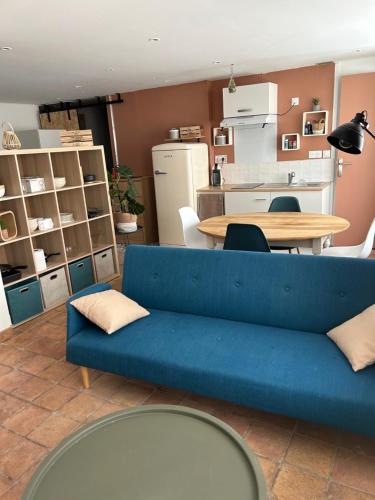 un salon avec un canapé bleu et une table dans l'établissement Appartement coeur de ville -Clim, ascenseur, wifi-, à Avignon